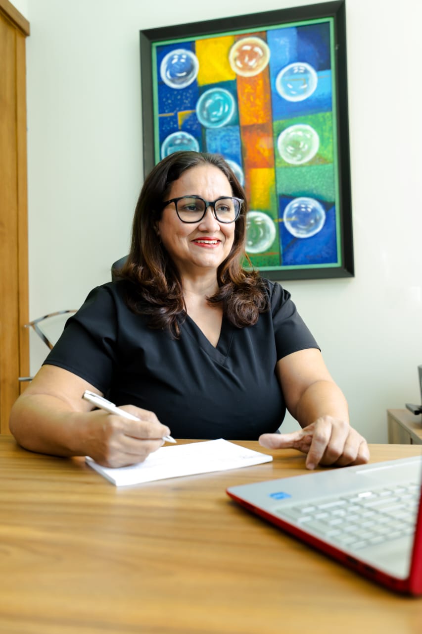 Dra. Ivette tomando notas médicas en el consultorio